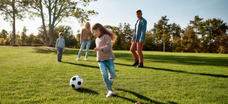 A family playing football in a park.